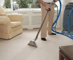 Carpet cleaning professional removing dirt and stains with a hot-water extraction tool in a home, Manchester, NH.